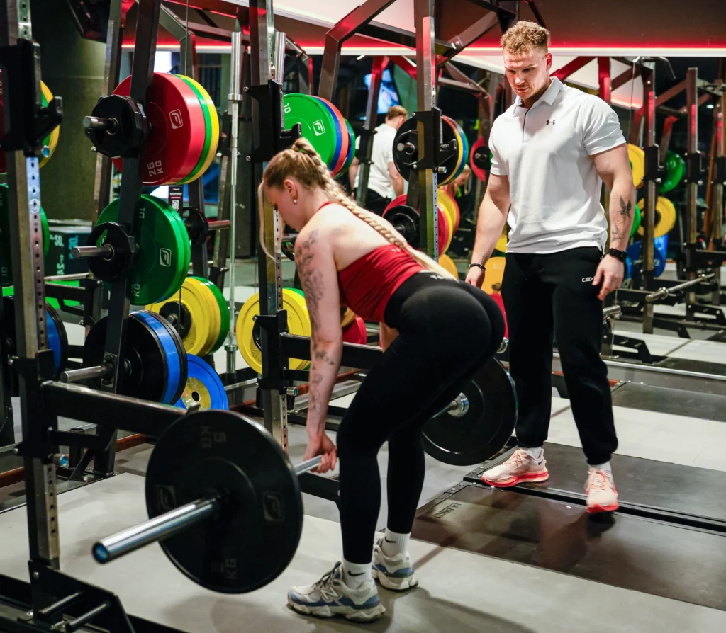 Jonas Buchner analysiert die eine Kundin die Gewichte hebt.